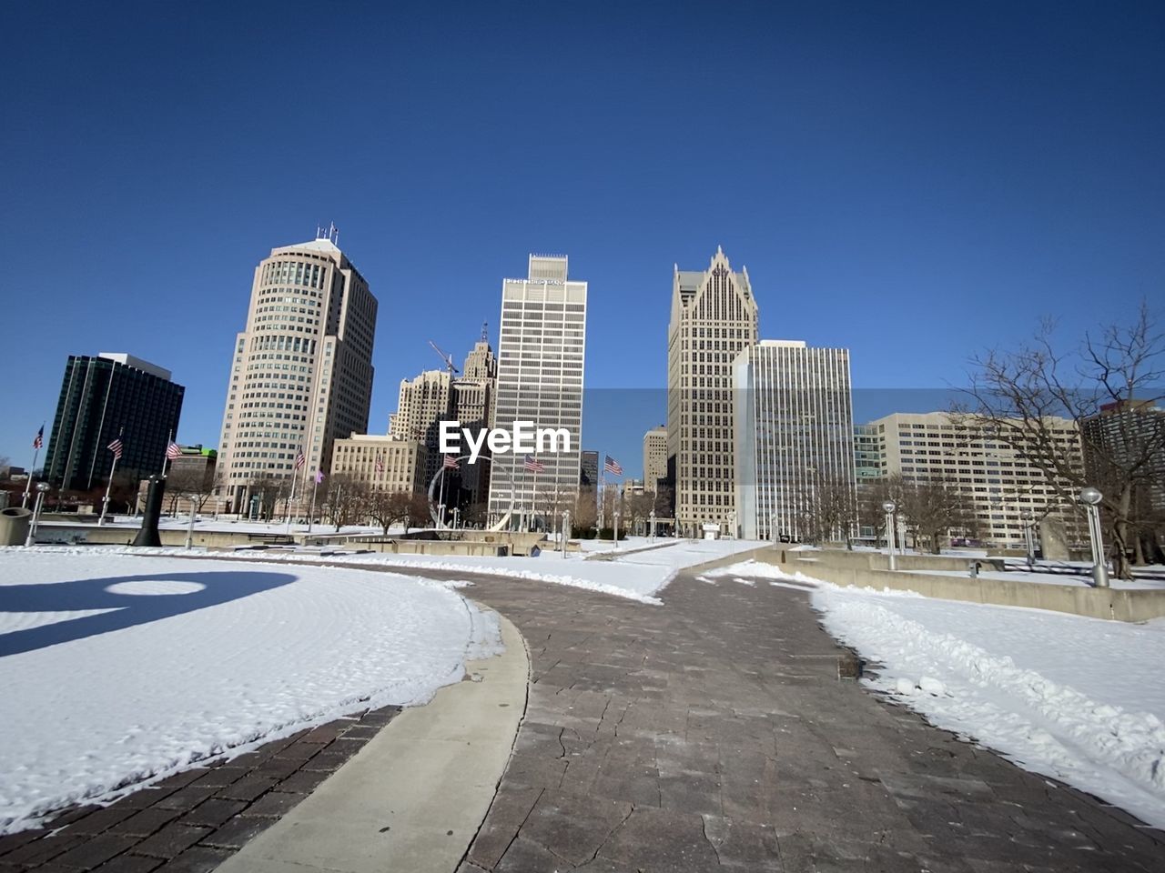 Modern buildings in city against clear blue sky