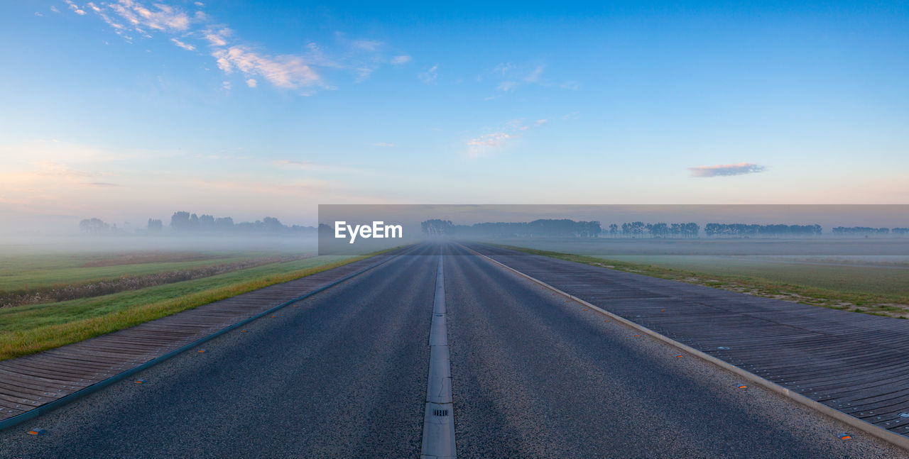 ROAD PASSING THROUGH LANDSCAPE AGAINST SKY