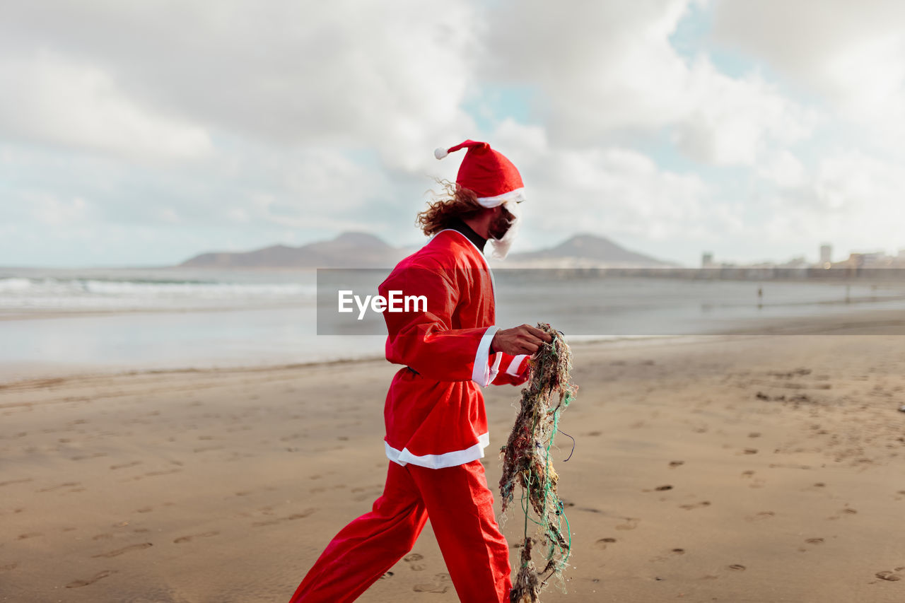 Full length of man standing on beach against sky