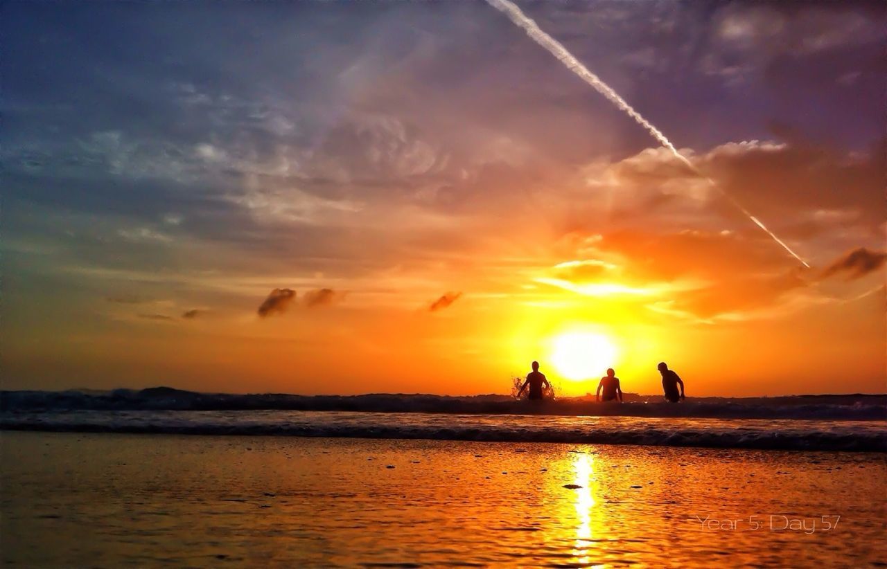 Silhouette of people taking bath in sea