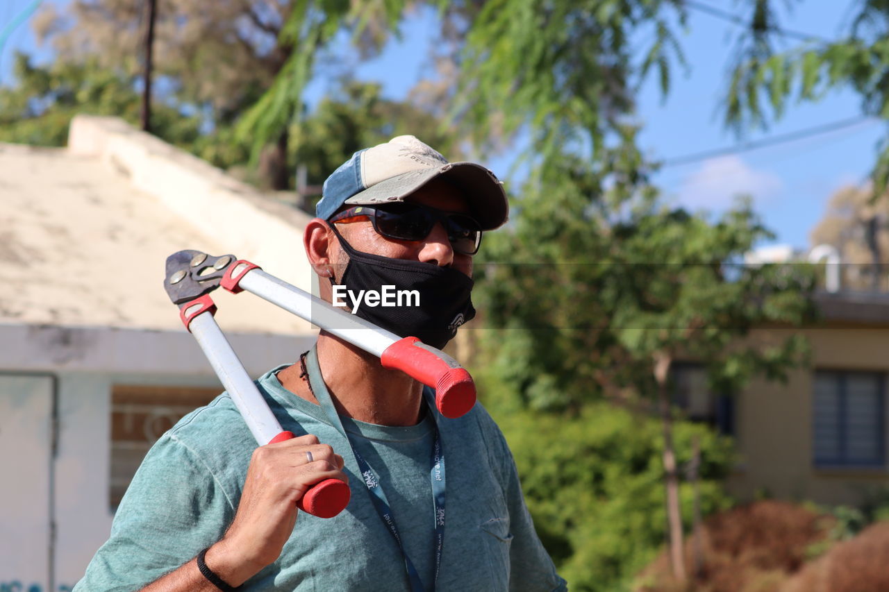 Full length portrait of man holding sunglasses