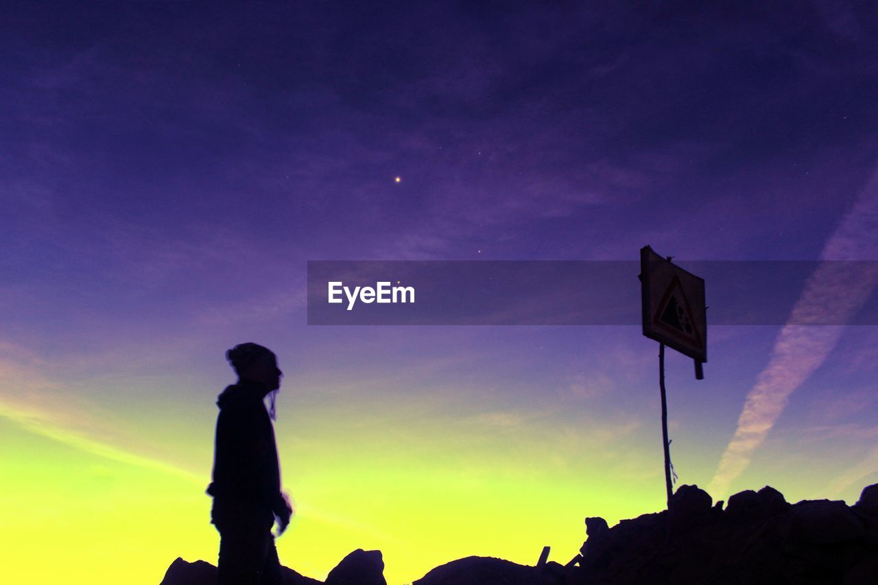 Low angle view of silhouette man against purple sky