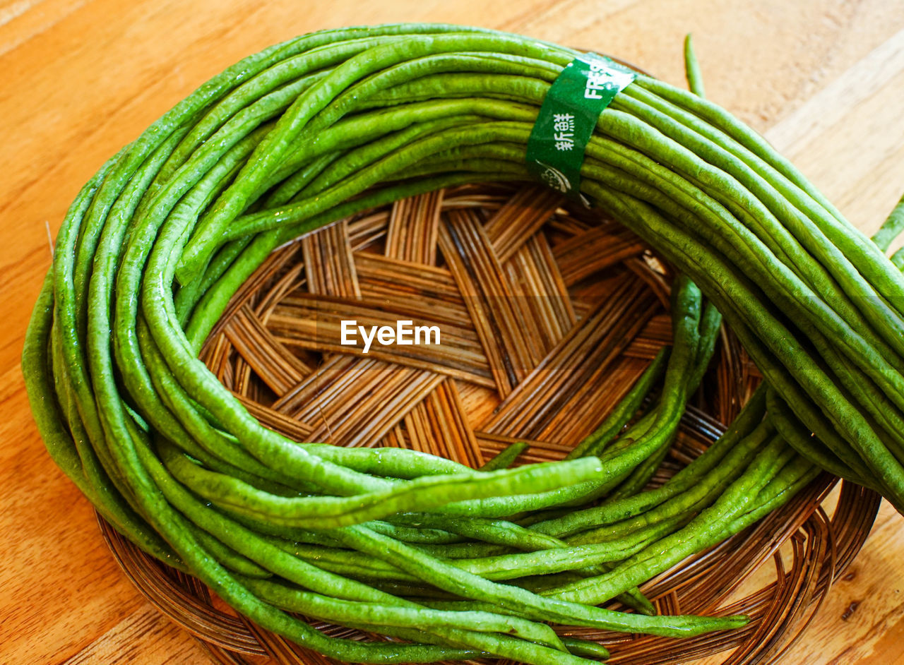 green, food and drink, food, wood, freshness, still life, healthy eating, wellbeing, high angle view, indoors, vegetable, produce, no people, table, close-up, directly above, green bean, large group of objects, plant