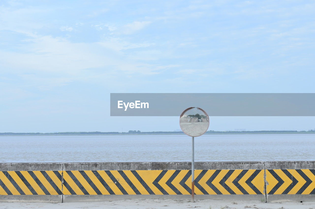 sky, water, sea, beach, nature, ocean, day, horizon, horizon over water, coast, no people, cloud, blue, beauty in nature, tranquility, shore, scenics - nature, vacation, tranquil scene, outdoors, sand, sign, land, communication, body of water, railing, guidance, reflection