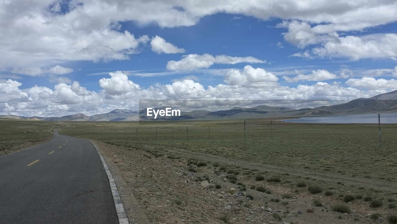 environment, landscape, cloud, sky, scenics - nature, road, mountain, horizon, transportation, land, beauty in nature, nature, plain, travel, field, non-urban scene, no people, tranquility, the way forward, mountain range, tranquil scene, plateau, travel destinations, day, snow, highway, remote, tourism, cold temperature, steppe, prairie, outdoors, blue, natural environment, winter, grassland, diminishing perspective, cloudscape, snowcapped mountain, empty road, grass, rural scene, vanishing point, horizon over land