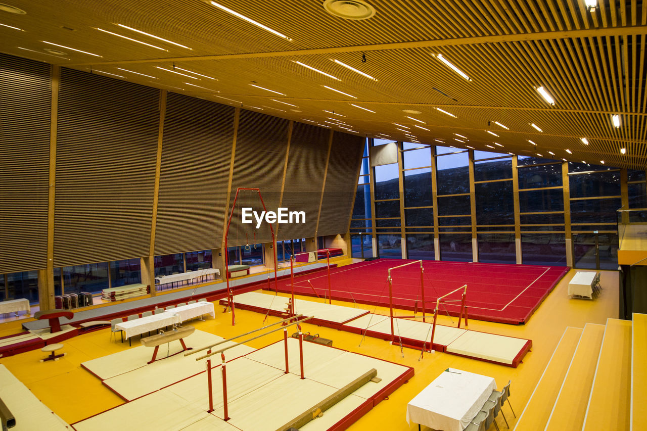 VIEW OF EMPTY CHAIRS AND TABLES IN ILLUMINATED ROOM