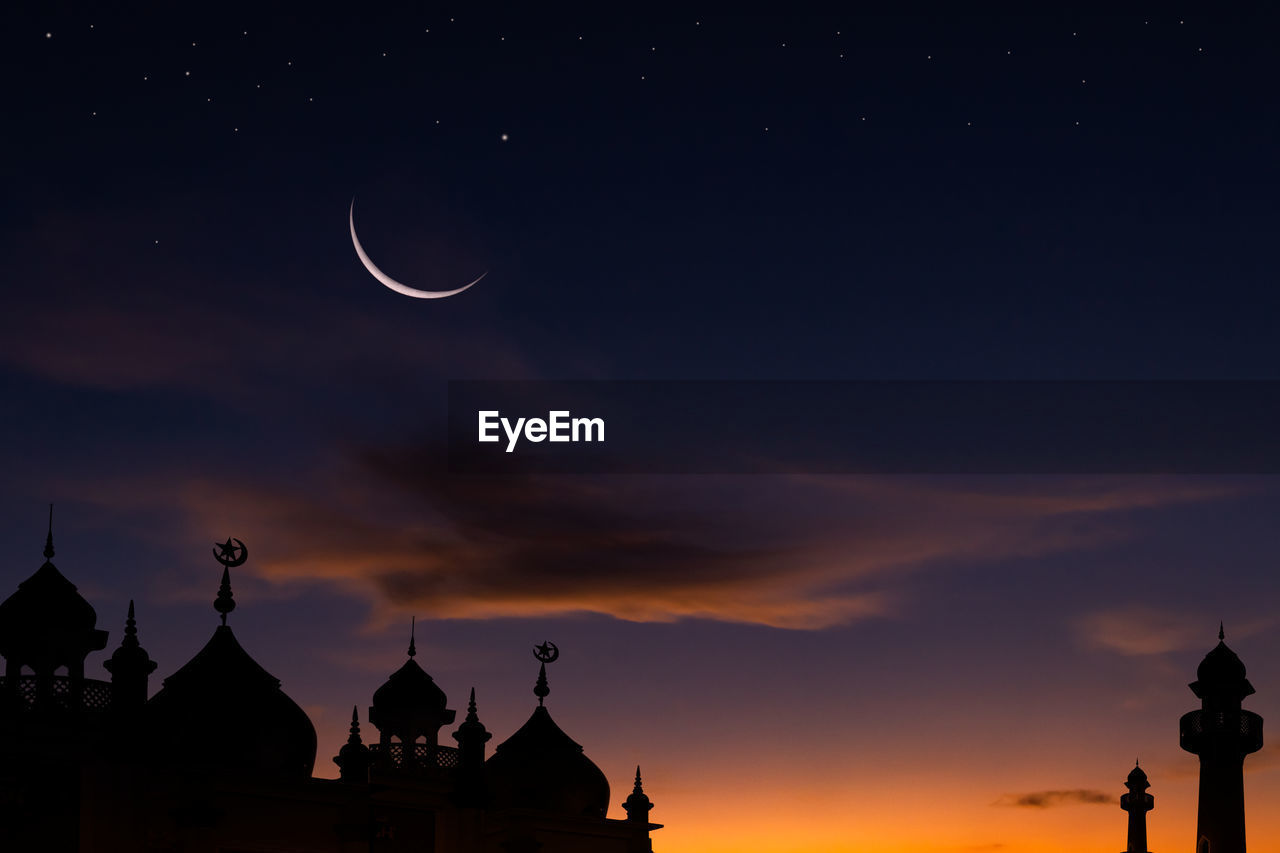 Silhouette mosques with crescent moon on twilight sky