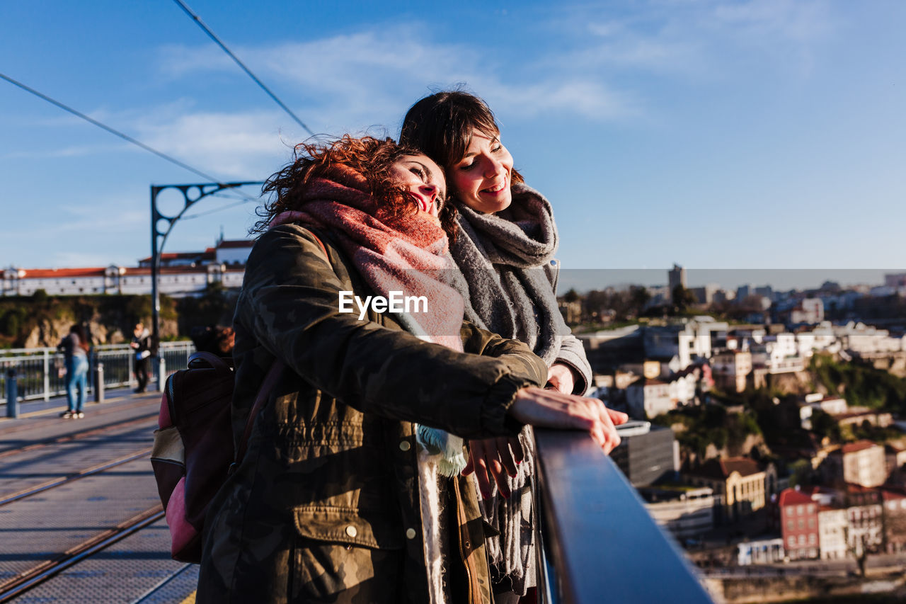 Two happy friends porto bridge sightseeing at sunset. travel, friendship and lifestyle