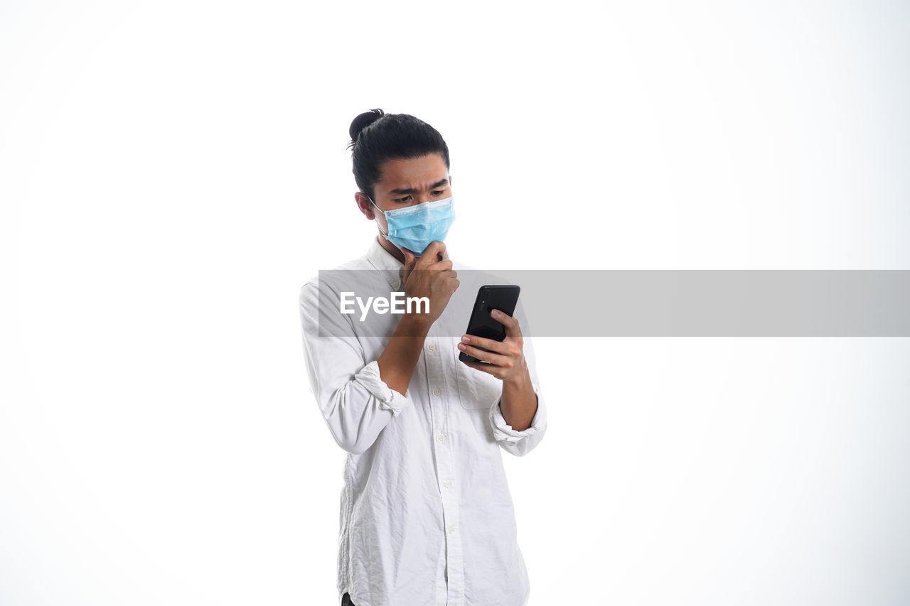 FULL LENGTH OF YOUNG MAN USING SMART PHONE