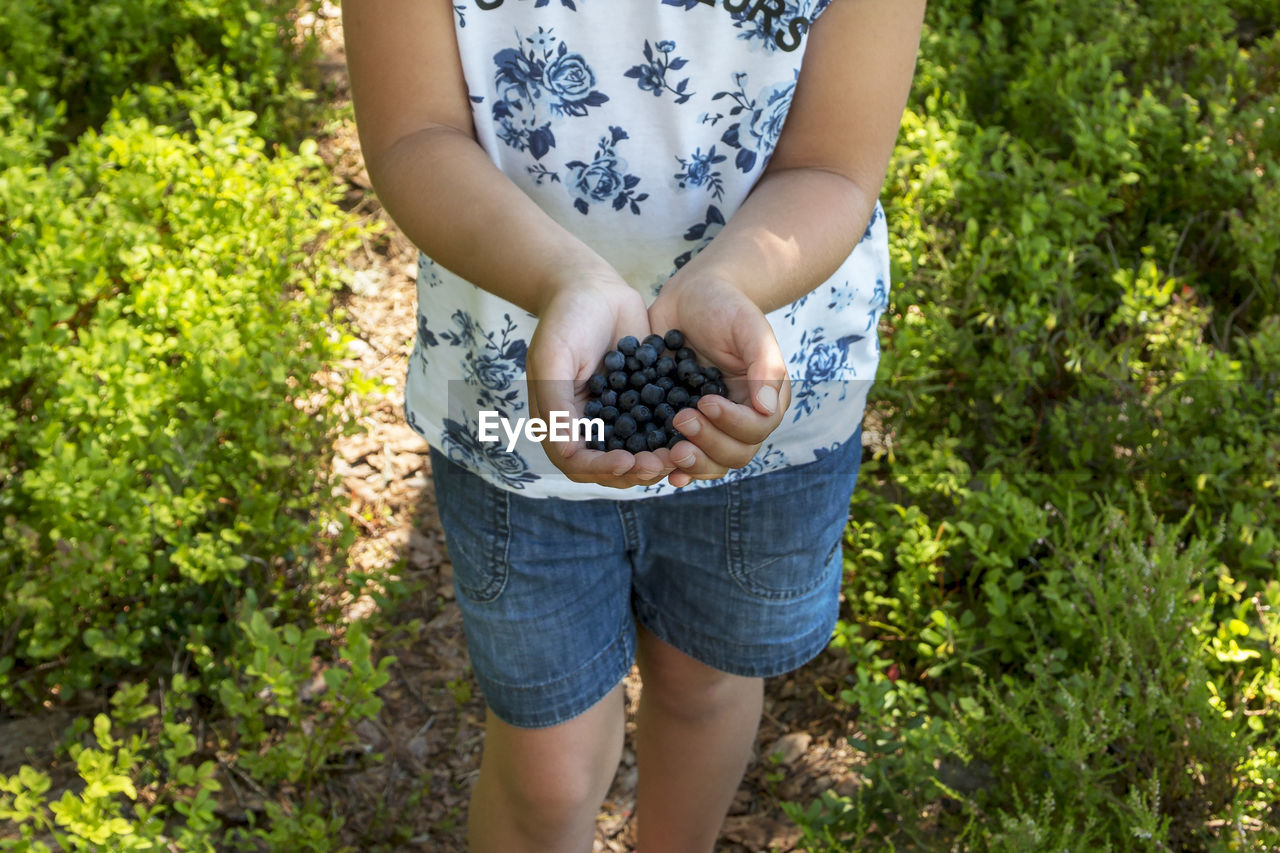 low section of man holding plant