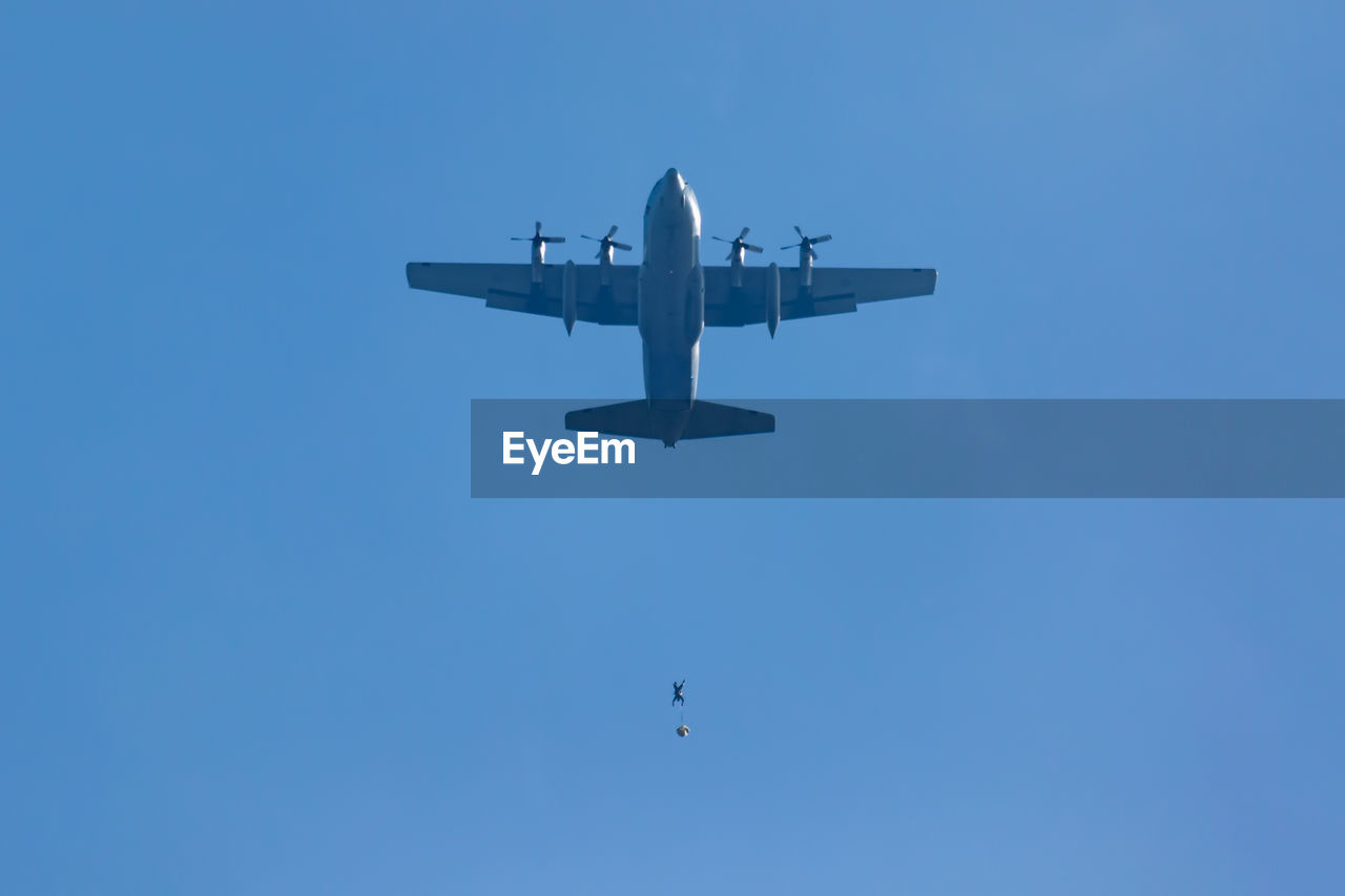 Low angle view of fighter airplane flying against clear sky