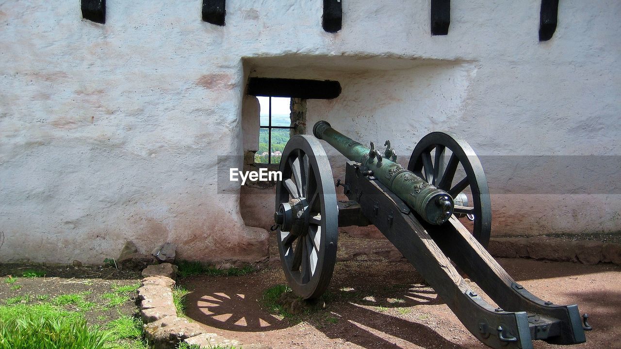 cannon, architecture, built structure, wall - building feature, iron, no people, building exterior, wheel, day, history, transportation, old, the past, outdoors, nature, wall, sunlight, building