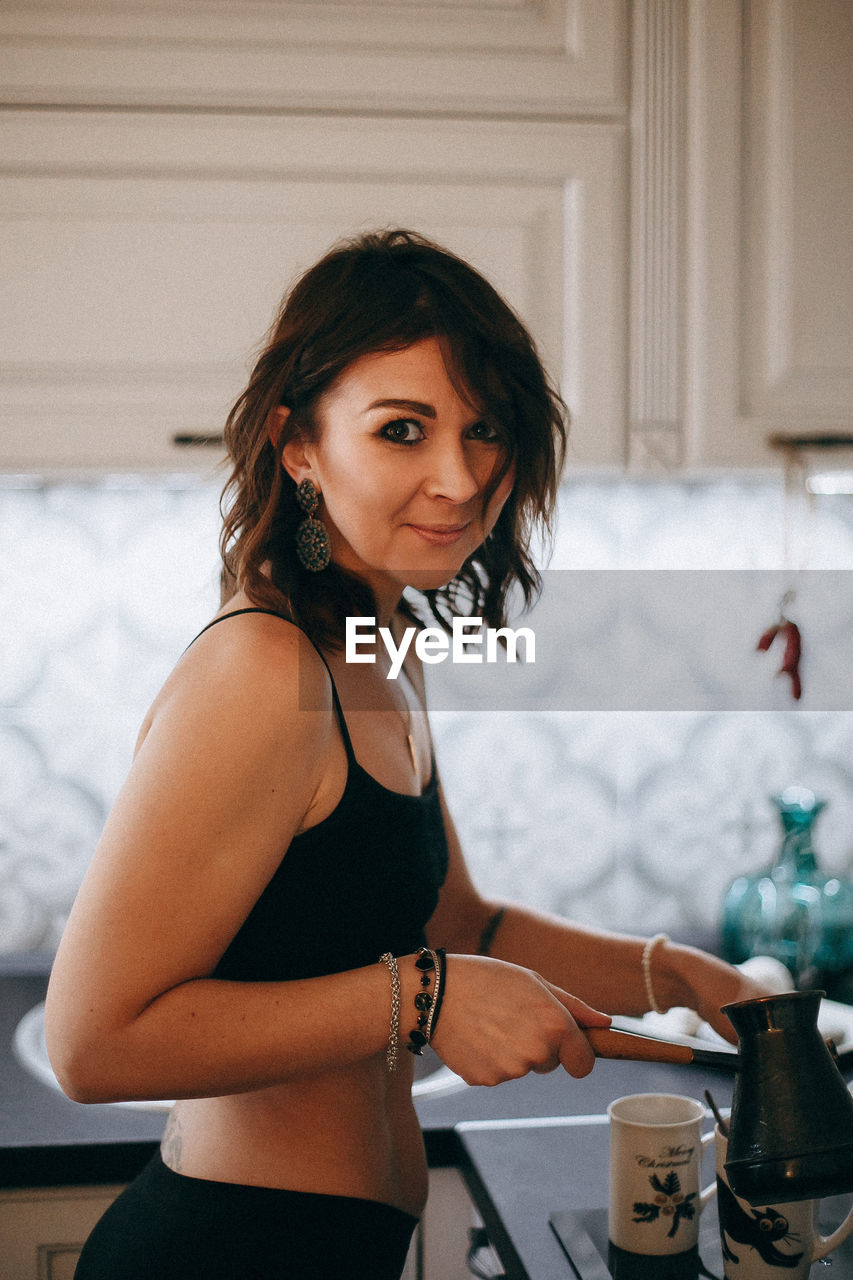 Portrait of woman preparing coffee at home