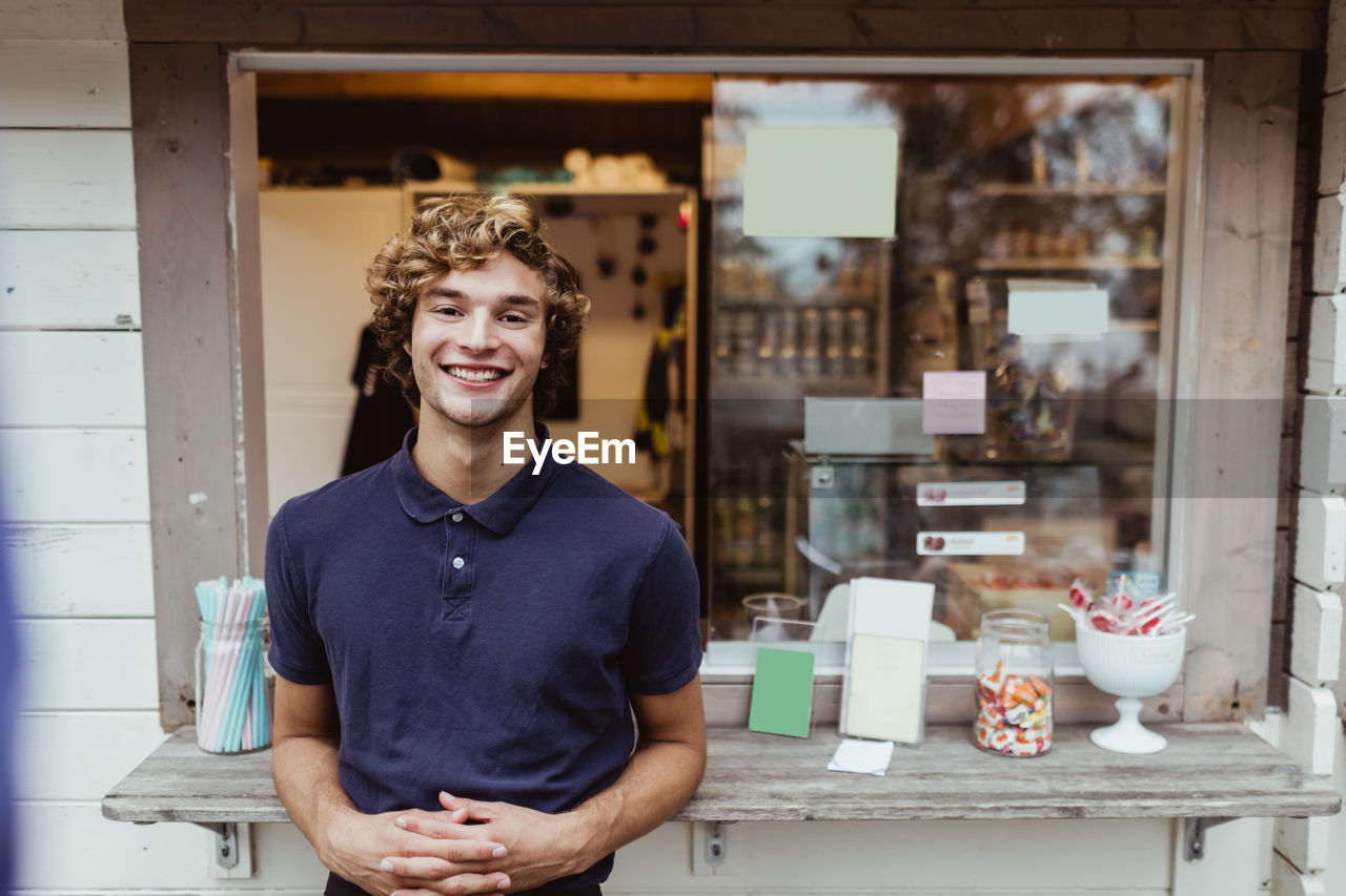 Portrait of confident male owner standing by concession stand