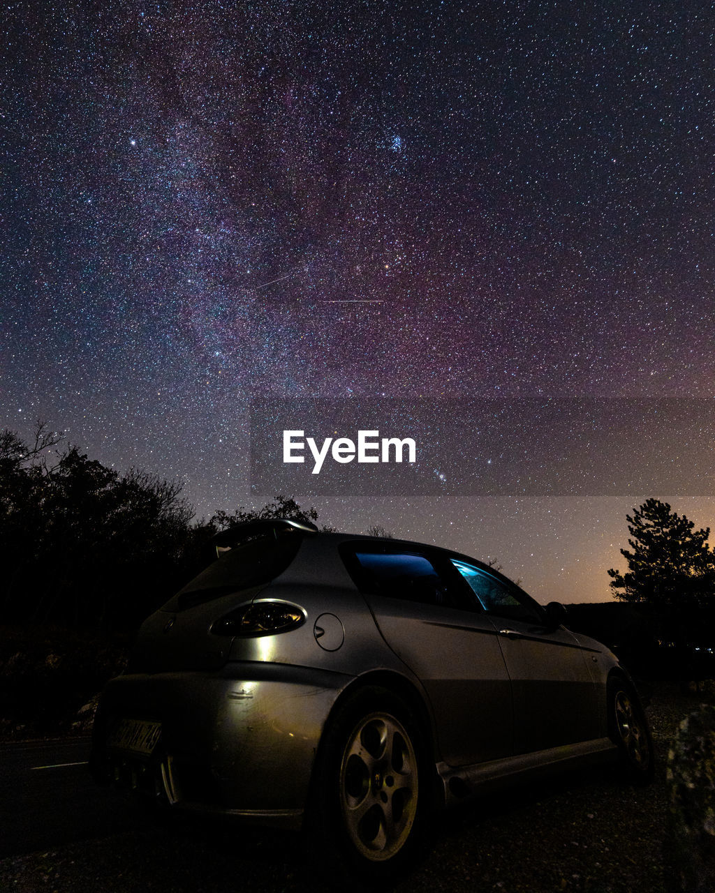 CAR AGAINST ILLUMINATED SKY AT NIGHT