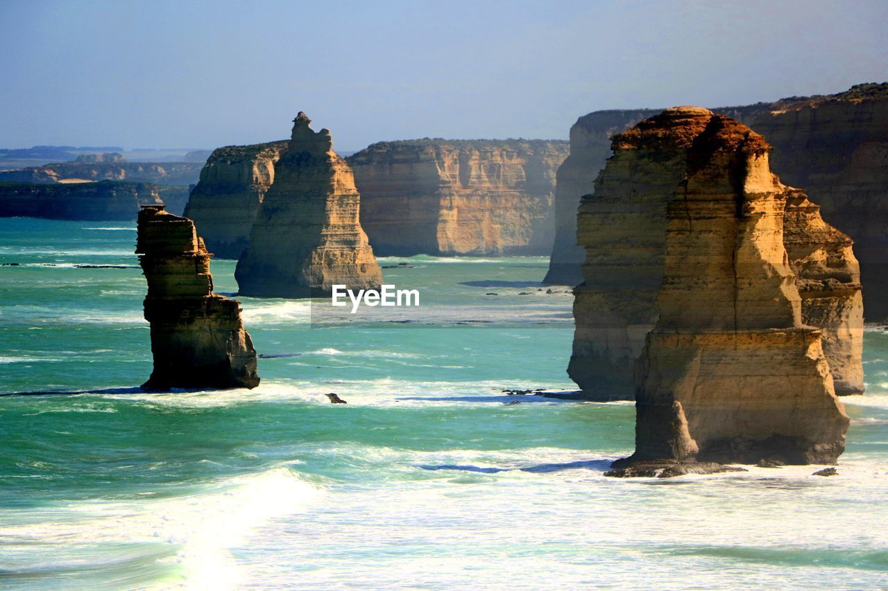 Built structure on cliff by sea against clear sky