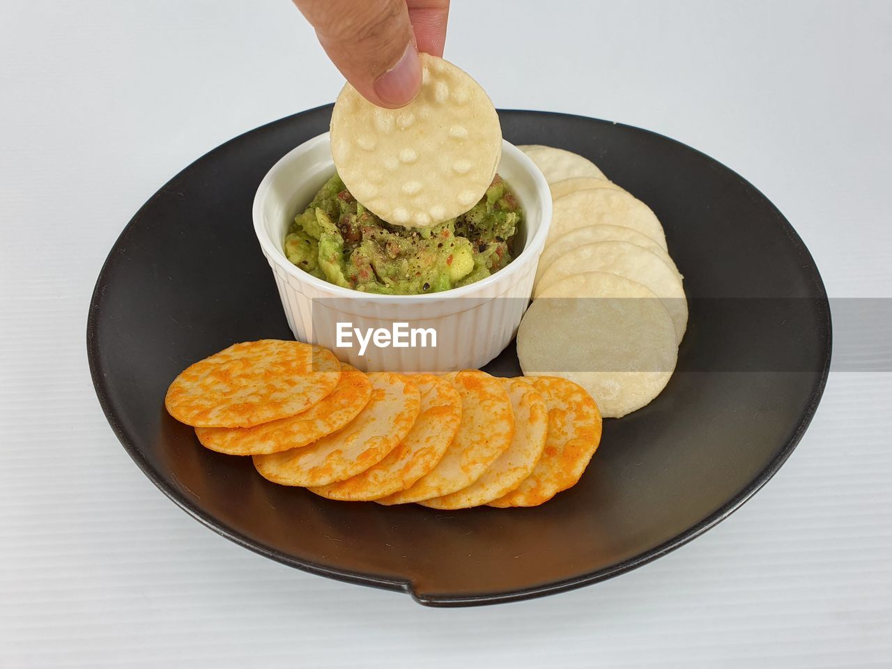 CLOSE-UP OF HAND HOLDING FOOD IN BOWL