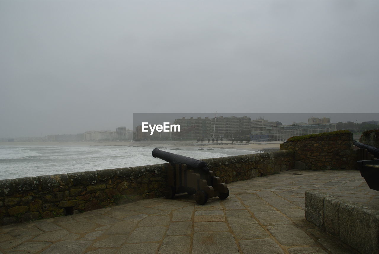 EMPTY BENCH OVERLOOKING CALM SEA