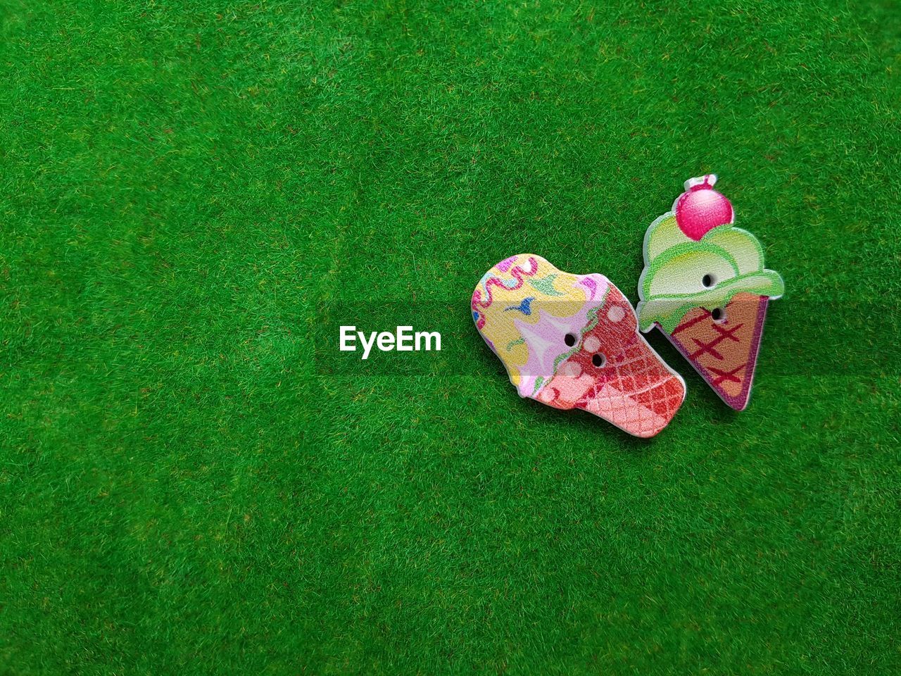 HIGH ANGLE VIEW OF TOYS ON GREEN LAND