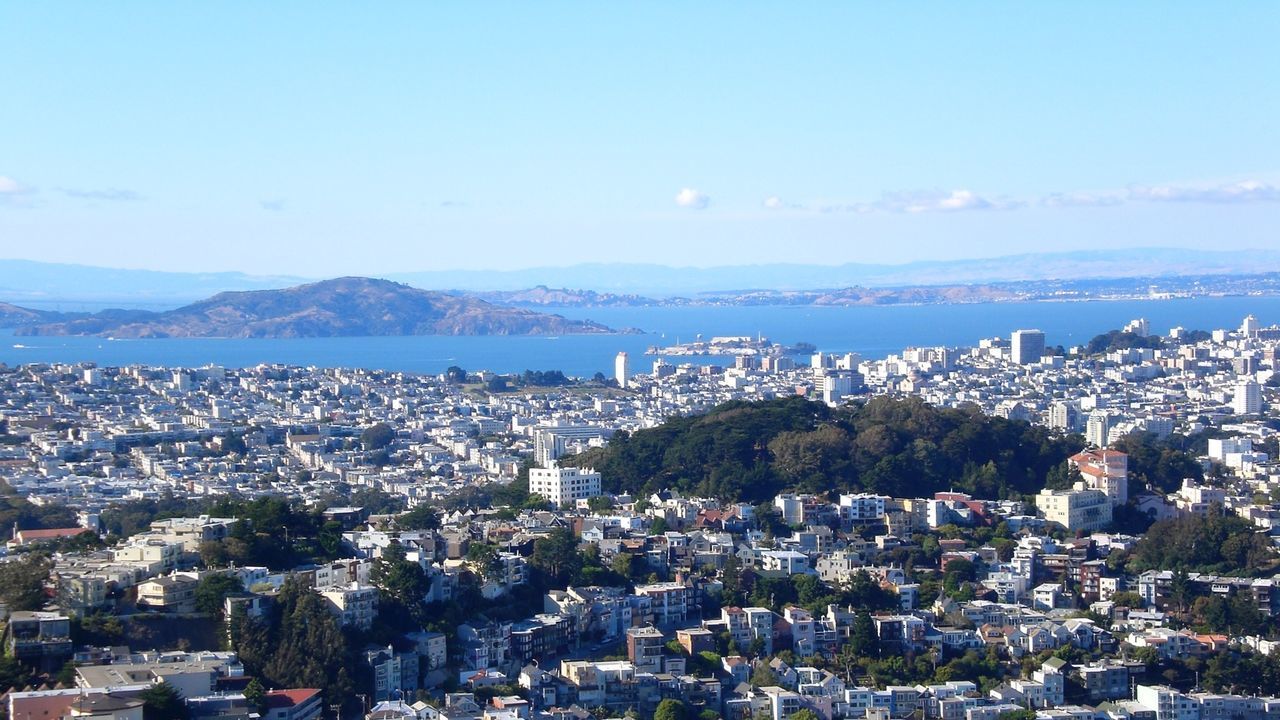 Aerial view of cityscape and sea against blue sky at alcatraz island