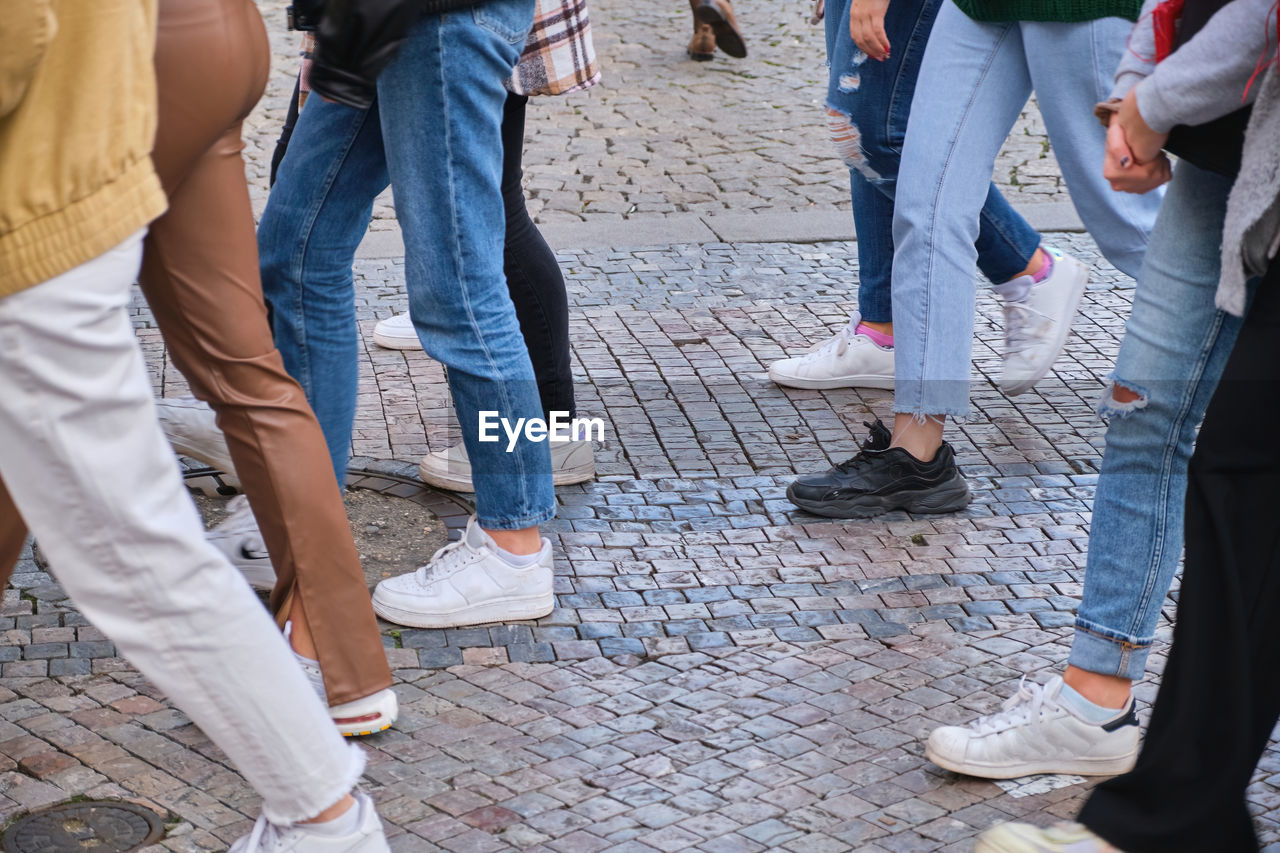 group of people, low section, human leg, women, city, men, adult, street, togetherness, lifestyles, casual clothing, day, human limb, limb, shoe, group, standing, leisure activity, medium group of people, spring, footwear, architecture, outdoors, friendship, footpath, walking, trousers, jeans, crowd, clothing, bonding, city life