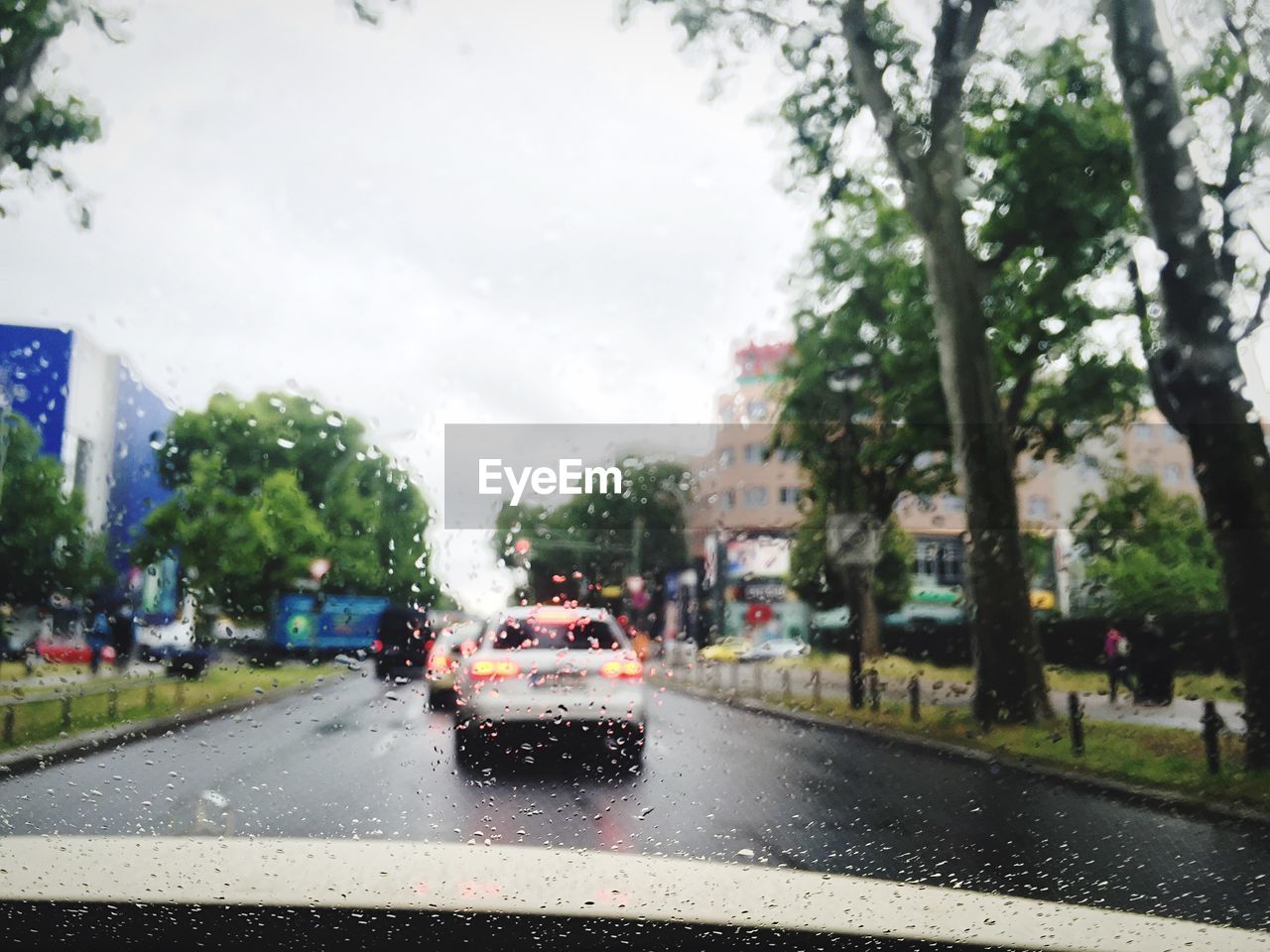 Cars on street seen through wet windshield