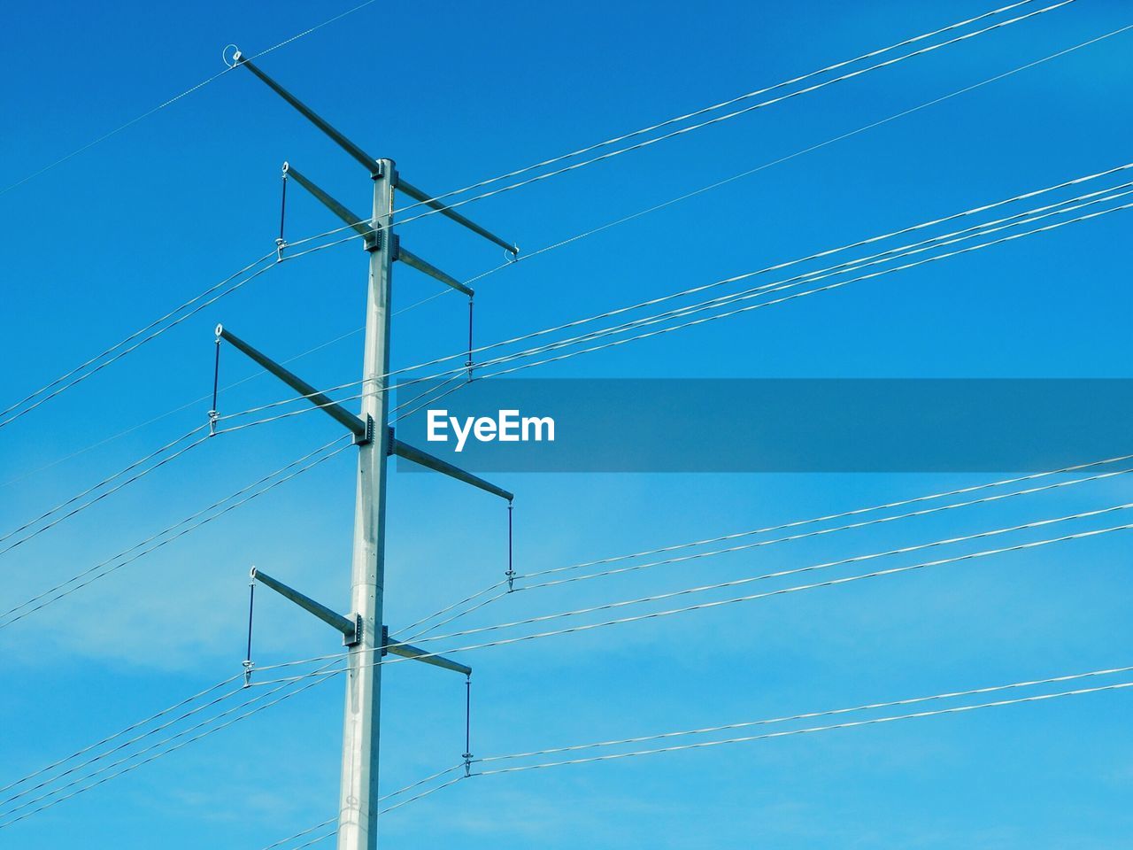 LOW ANGLE VIEW OF WINDMILLS AGAINST BLUE SKY