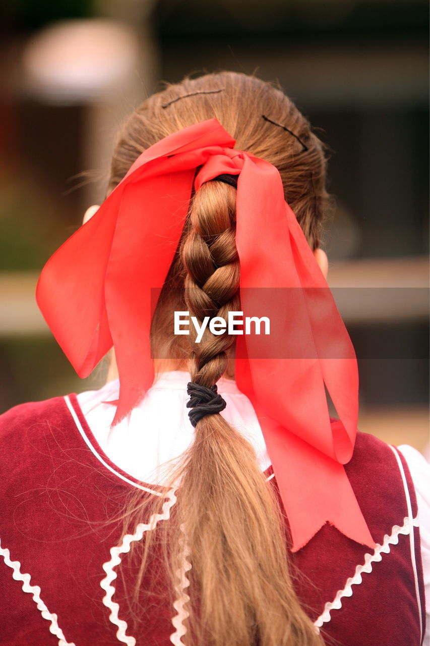 Red ribbon tied on braided hair