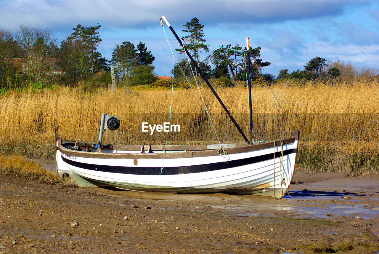 Boat moored at shore against sky