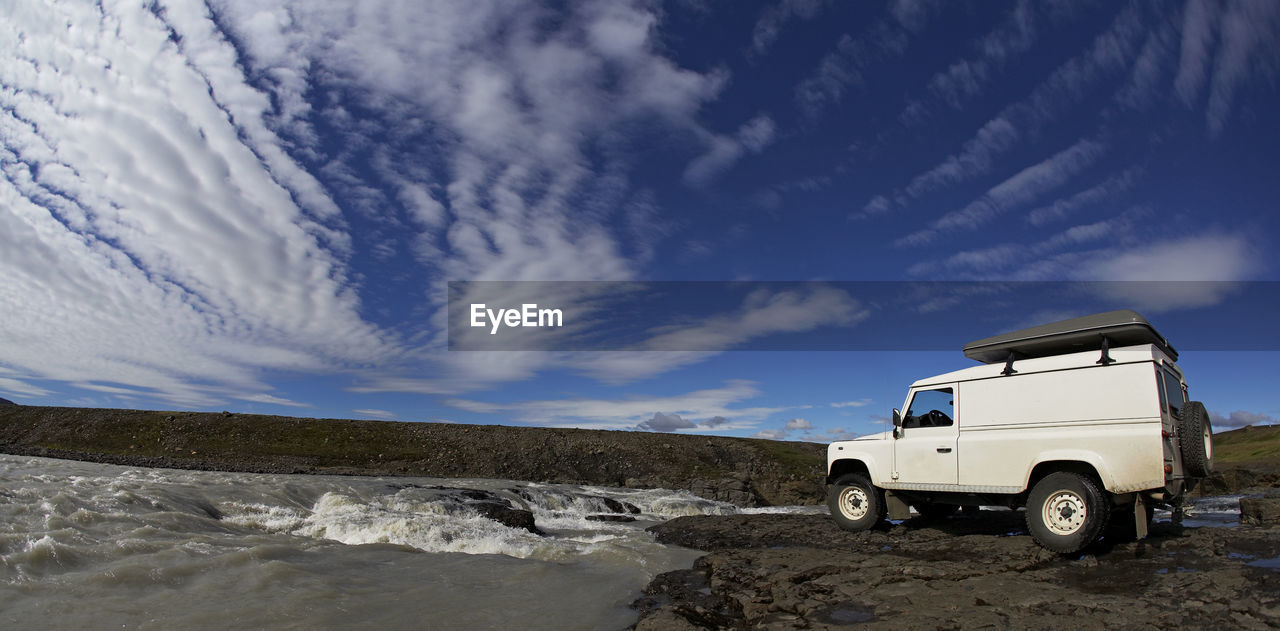 White suv standing at the edge of a waterfall