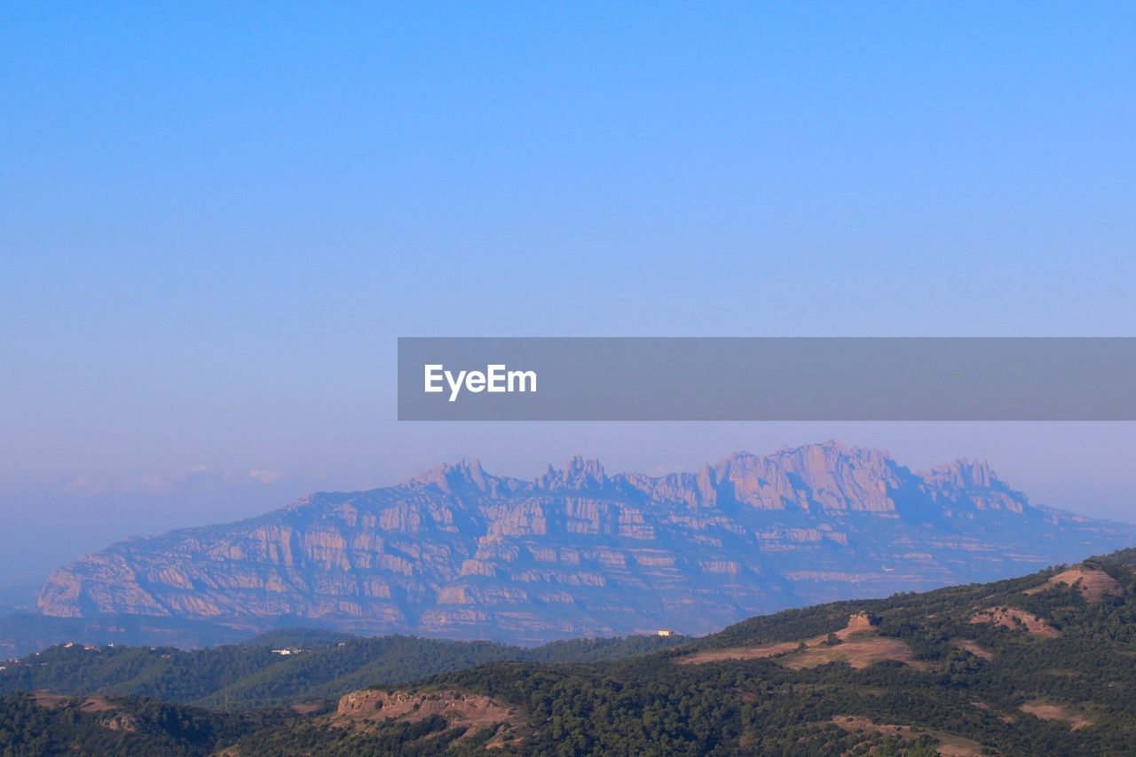 View of mountain range against blue sky