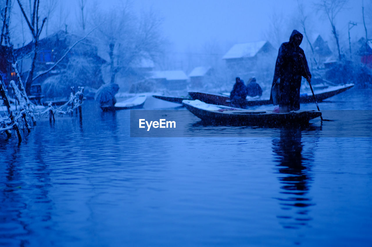 Man on boat in sea against sky