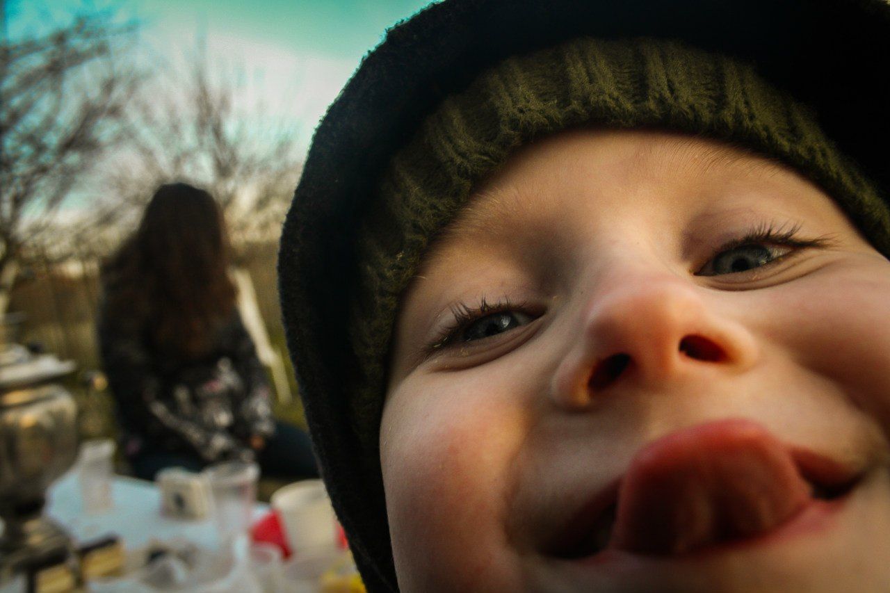 Close-up portrait of girl sticking out tongue outdoors