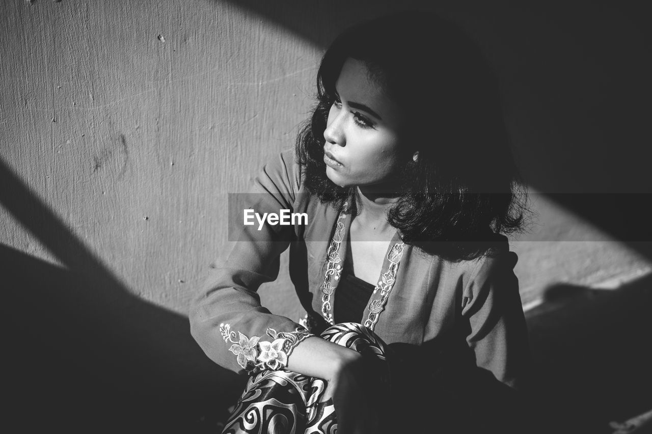 High angle view of young woman sitting in darkroom