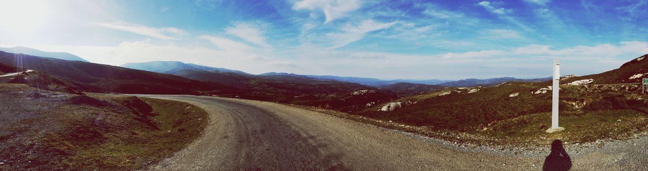 Panoramic shot of empty country road along landscape