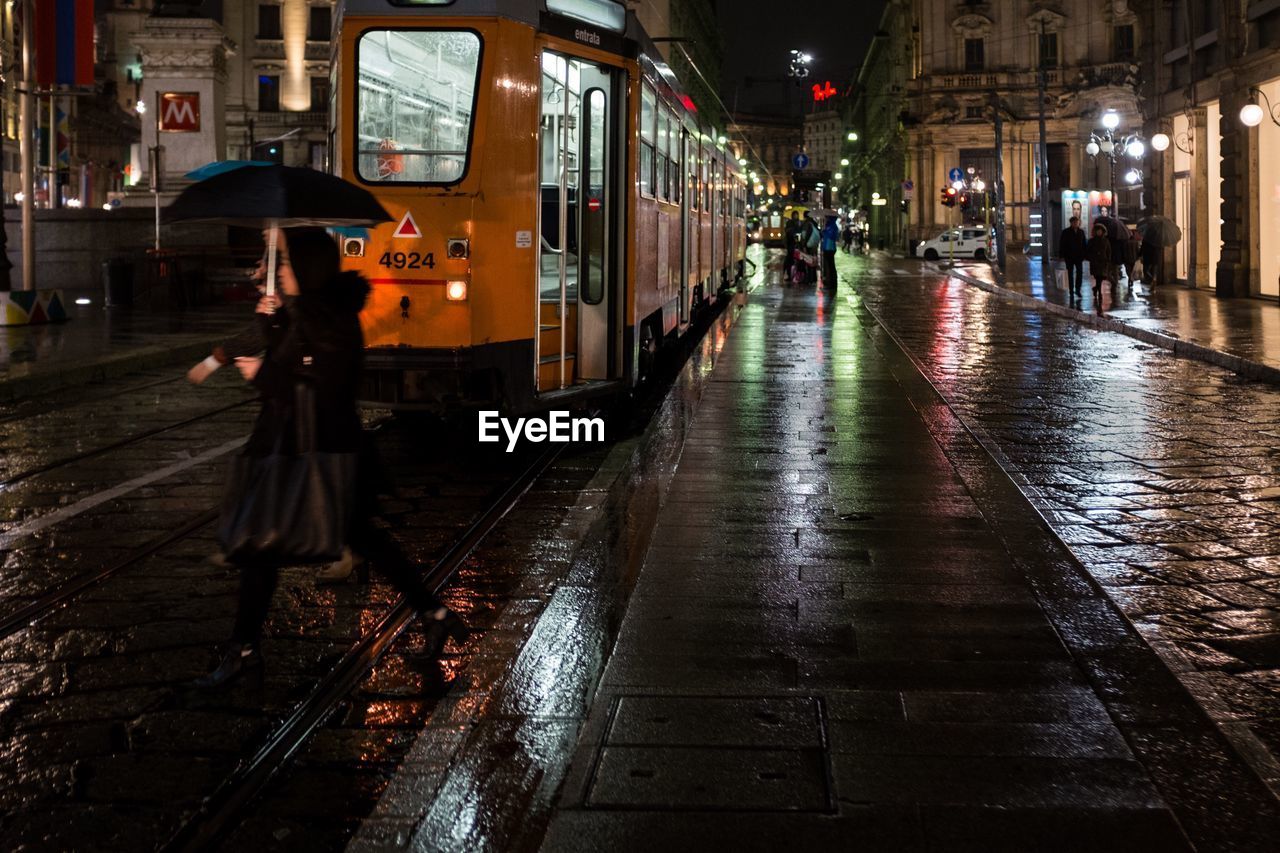 Tram on wet street at night