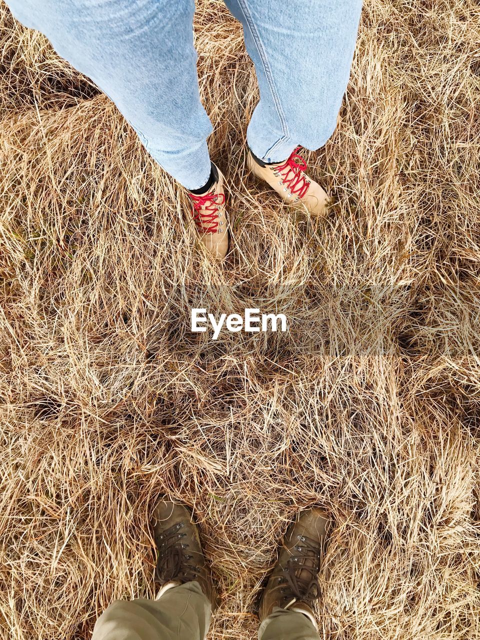 LOW SECTION OF MAN STANDING ON HAY BALES