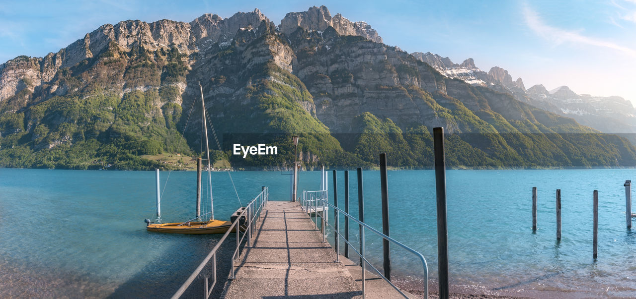 Scenic view of sea by mountains against sky