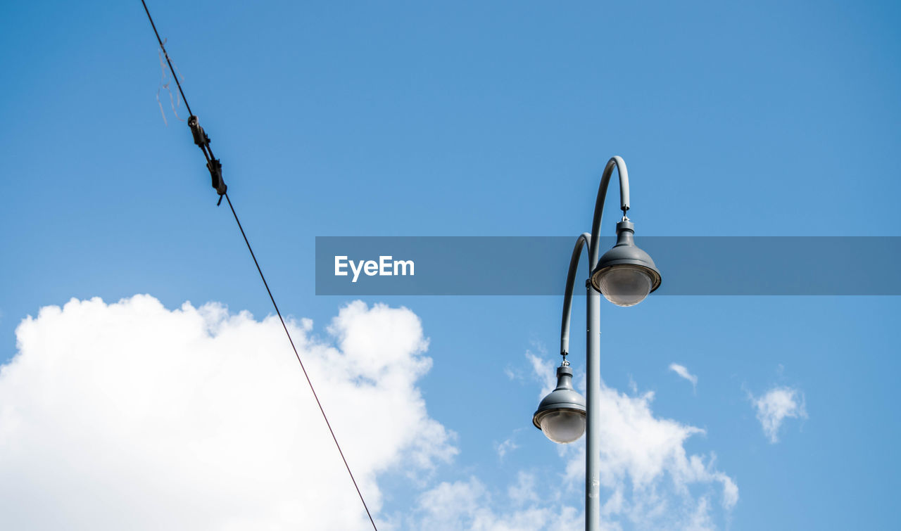 LOW ANGLE VIEW OF CABLES HANGING AGAINST BLUE SKY