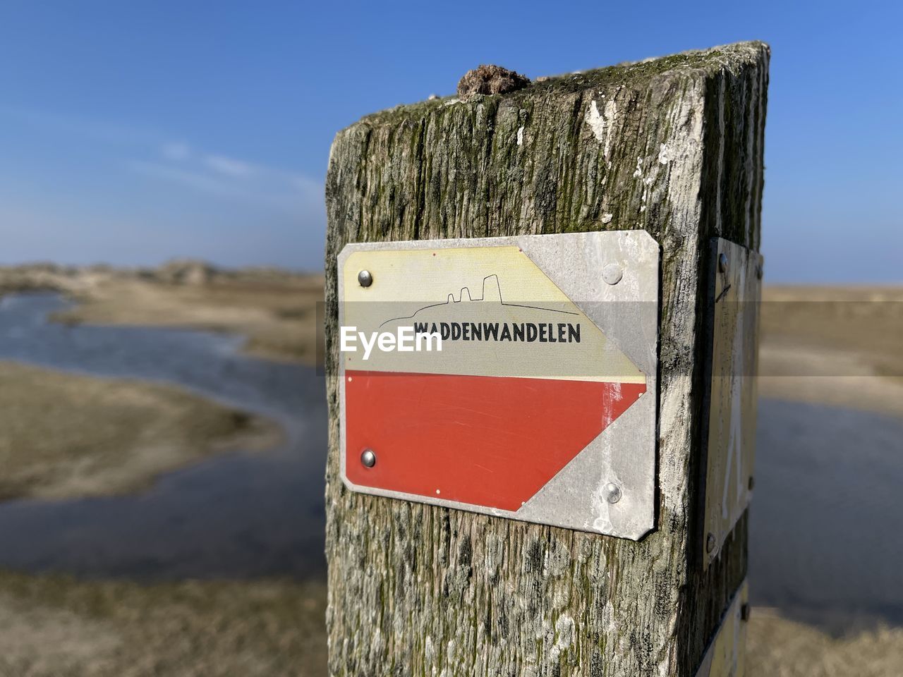 sign, communication, warning sign, no people, blue, nature, water, text, day, close-up, focus on foreground, road sign, guidance, information sign, outdoors, western script, wood, reflection, lake, winter, sky