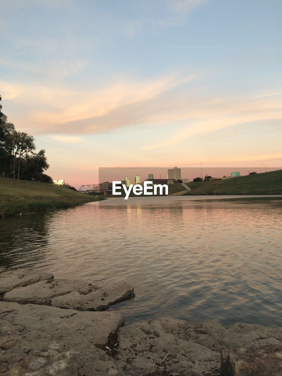 Scenic view of lake in city against cloudy sky