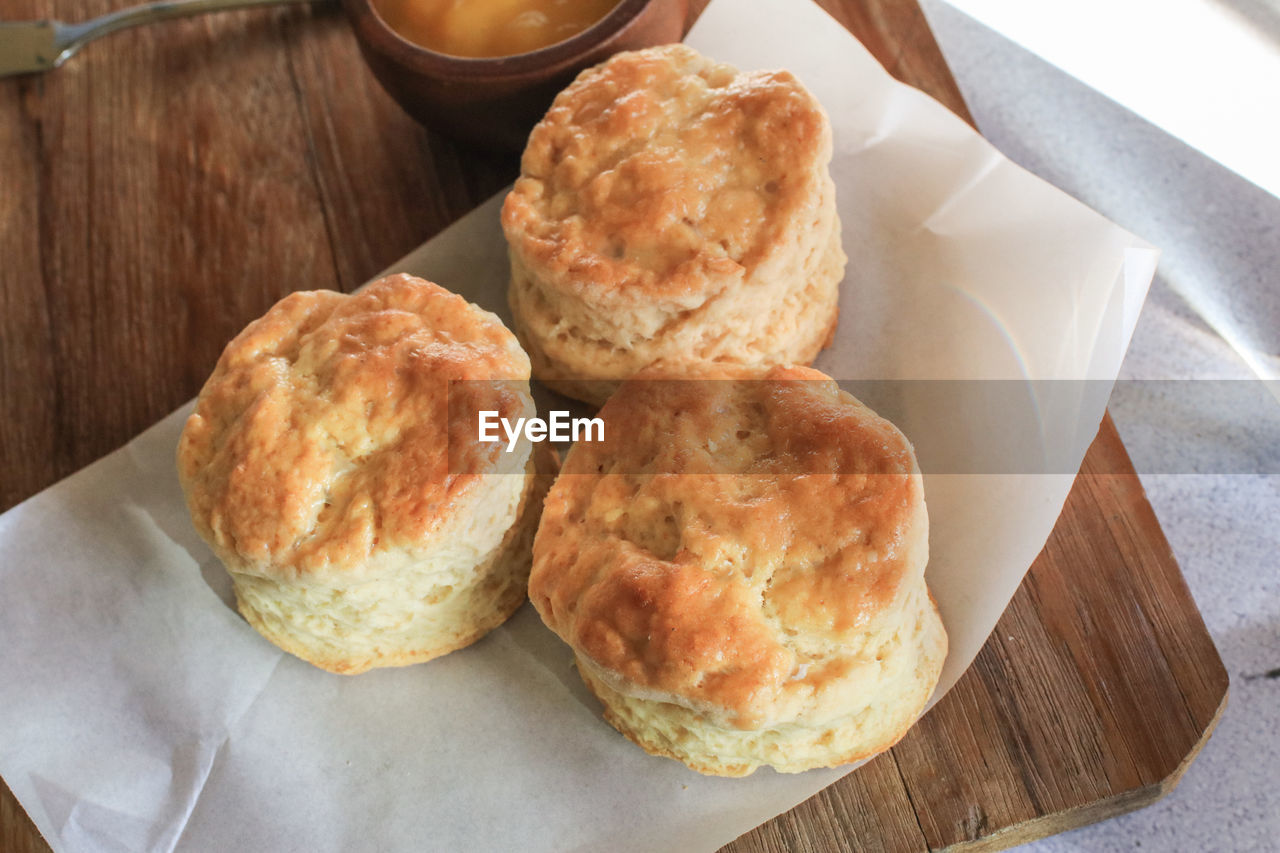 food and drink, food, fast food, freshness, dessert, bread, dish, table, breakfast, meal, baked, no people, indoors, high angle view, healthy eating, wood, scone, still life, produce, paper, close-up, wellbeing, french food