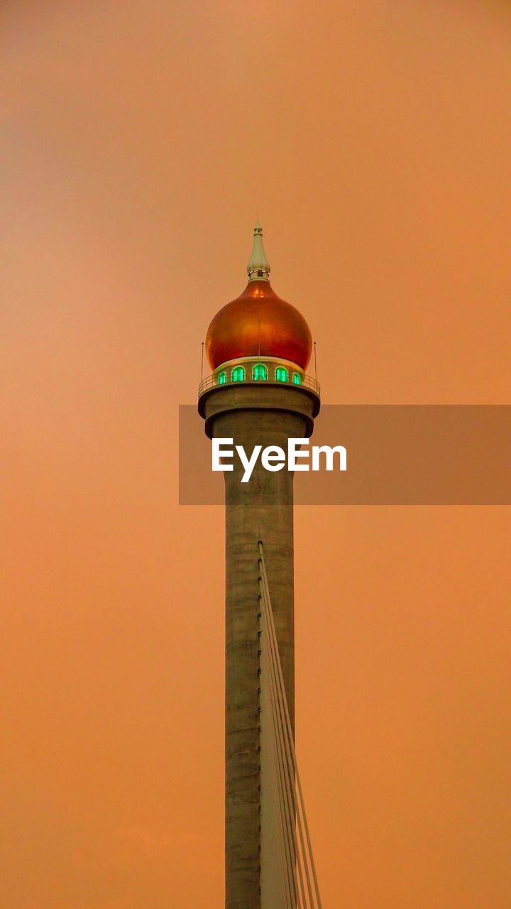 LOW ANGLE VIEW OF BUILDING AGAINST ORANGE SKY