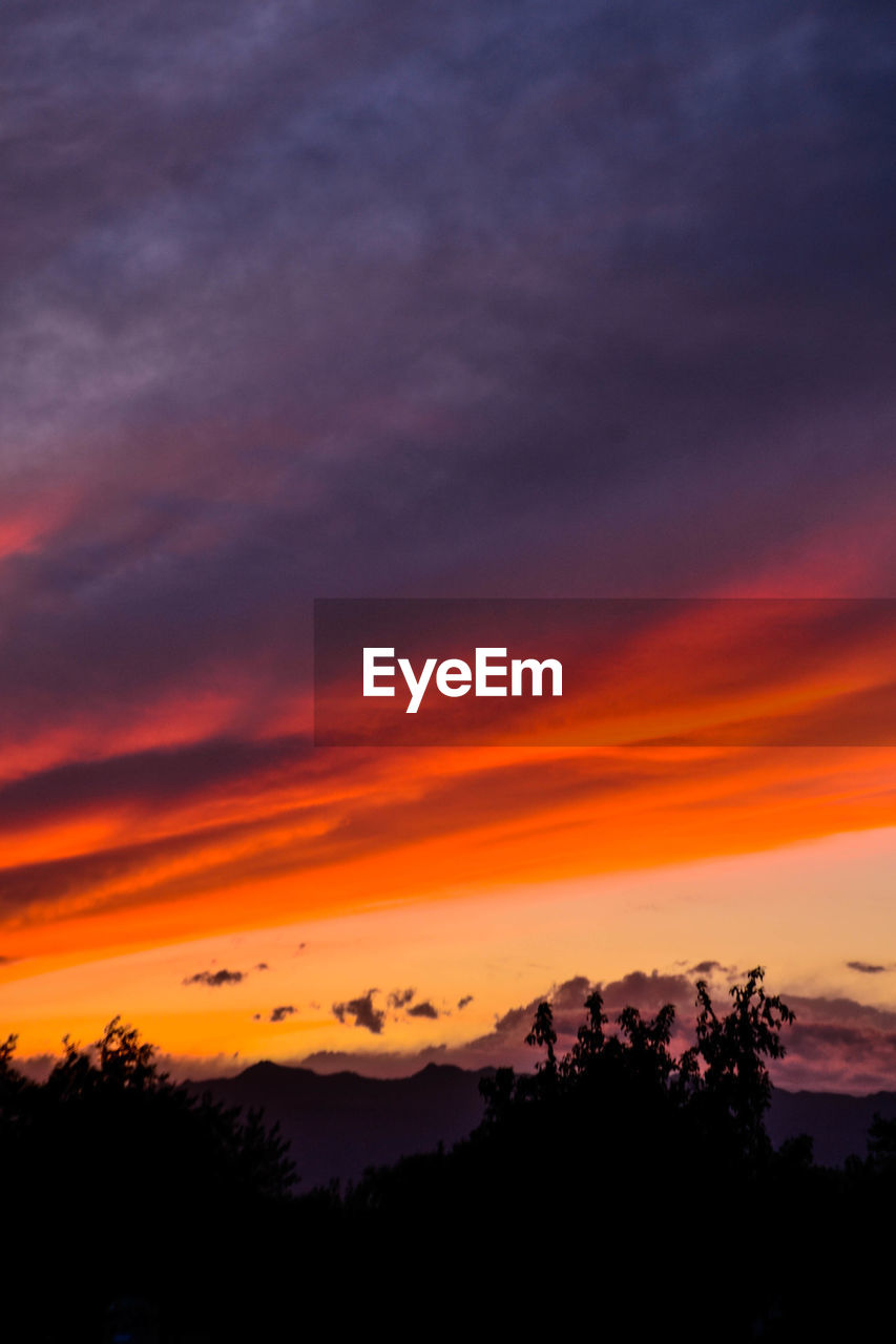 SCENIC VIEW OF DRAMATIC SKY OVER SILHOUETTE LANDSCAPE