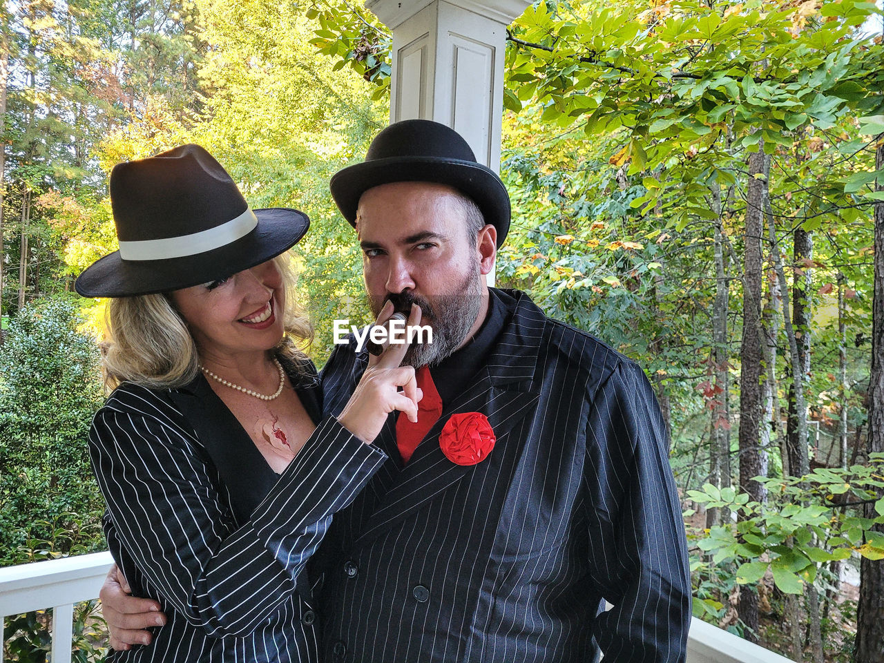 Millennial couple dressed as gangsters for halloween party in neighborhood.