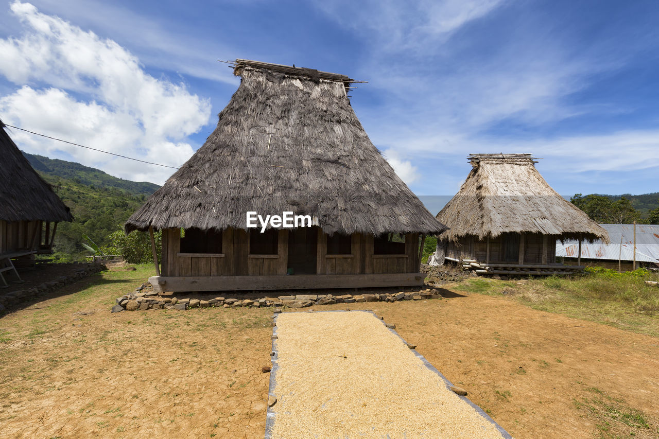 HOUSES AGAINST SKY ON FIELD