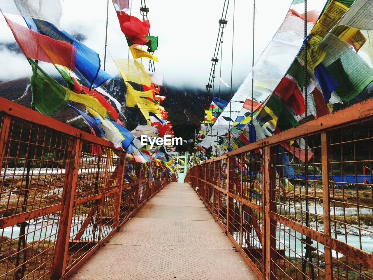 Bunting flags hanging over narrow footbridge at yumthang valley