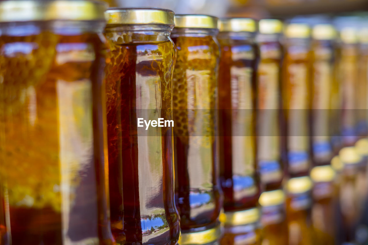 CLOSE-UP OF GLASS BOTTLES IN SHELF