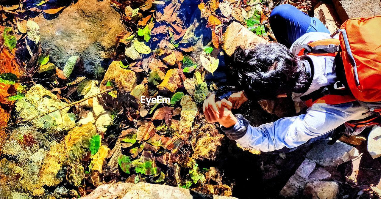 HIGH ANGLE VIEW OF MEN HOLDING ROCKS