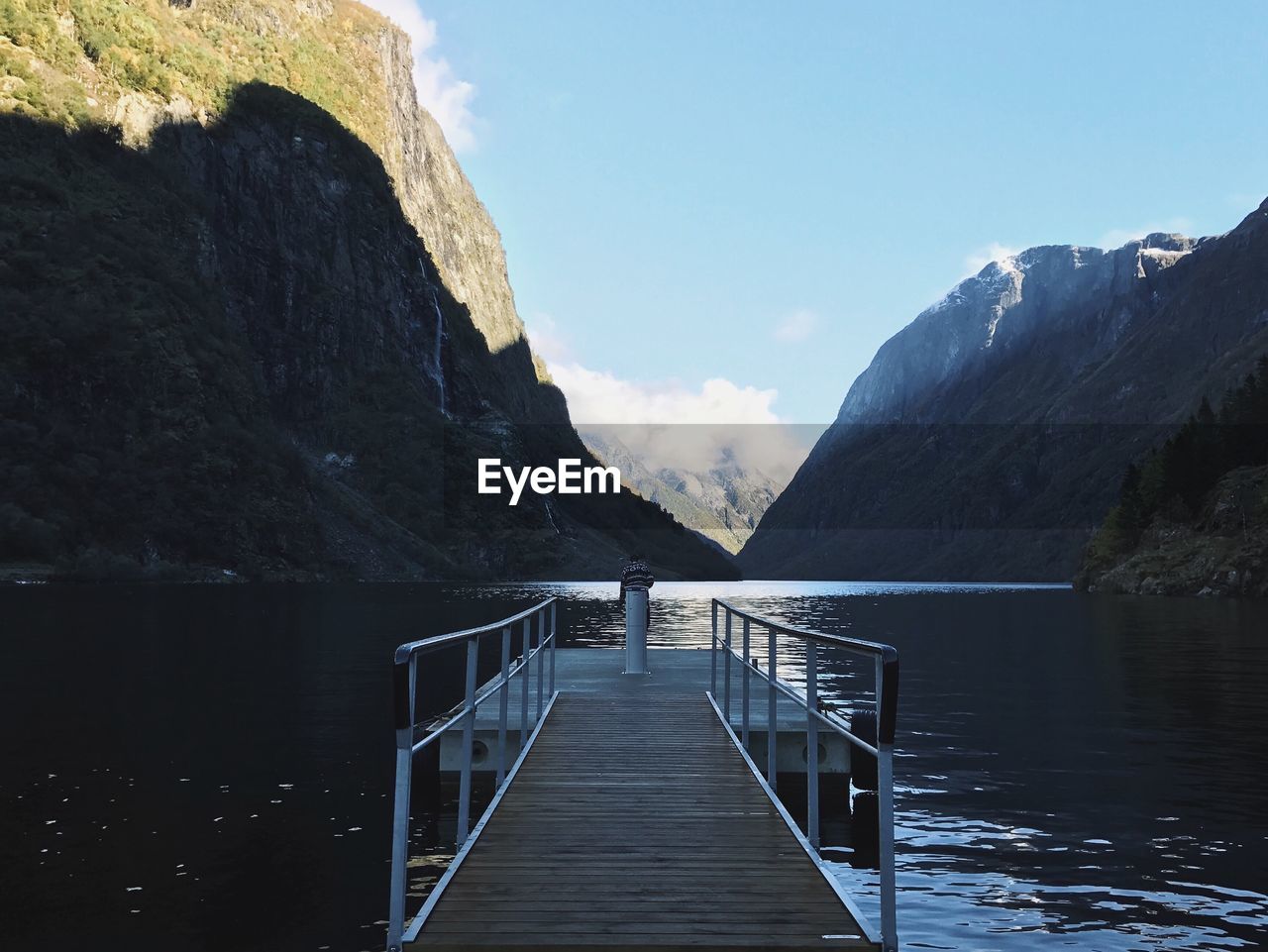 Scenic view of pier on lake against mountains and sky